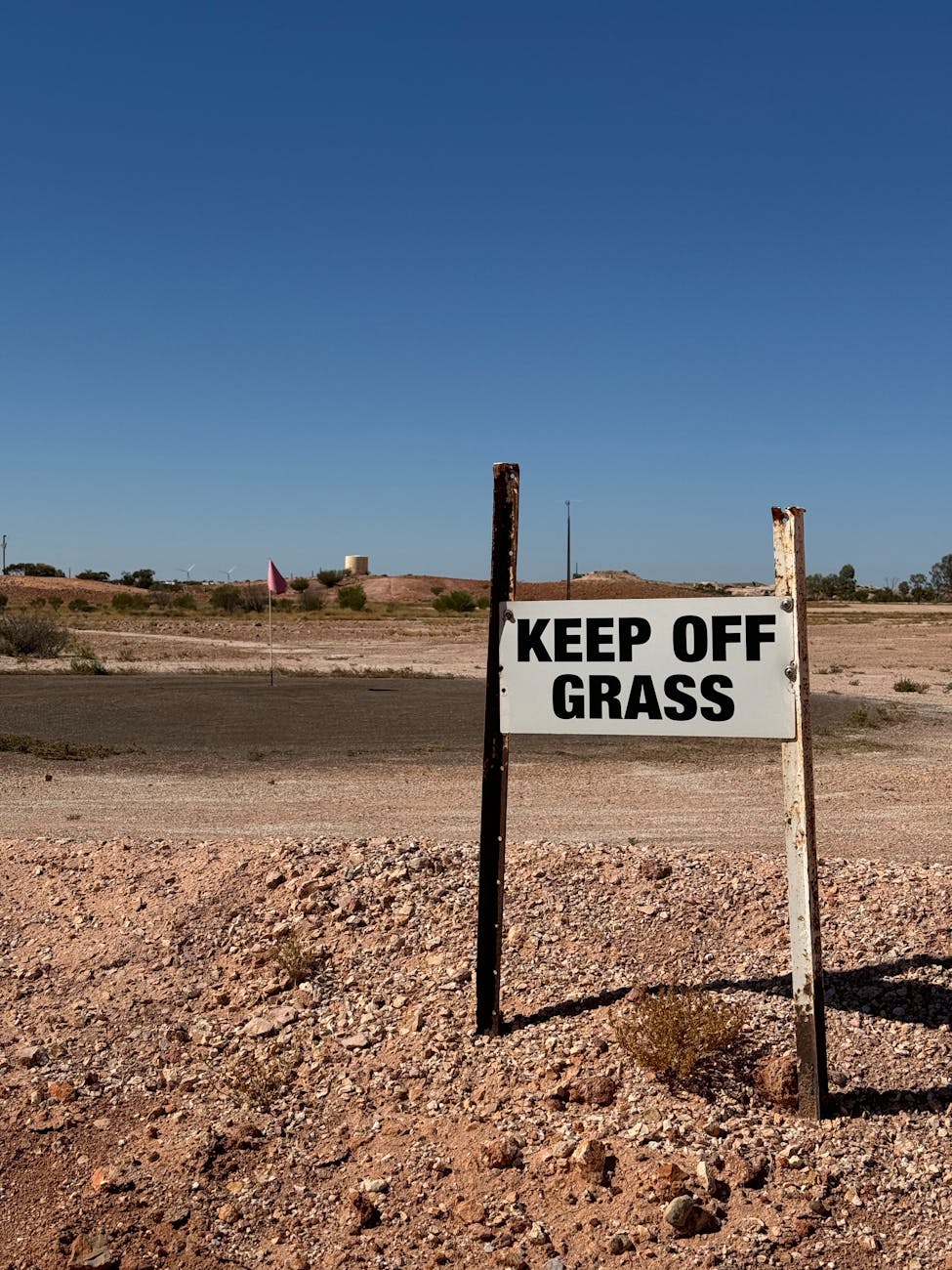 desert scene with keep off grass sign