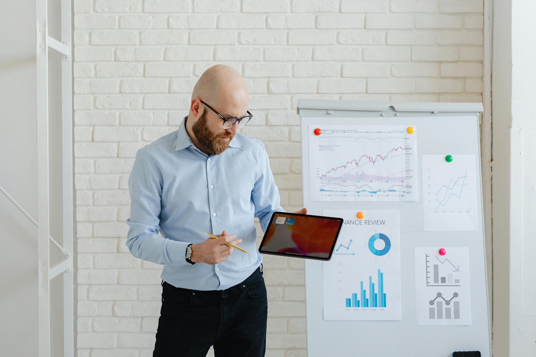 man in light blue long sleeve shirt holding black digital tablet